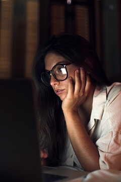 Woman at night working on laptop