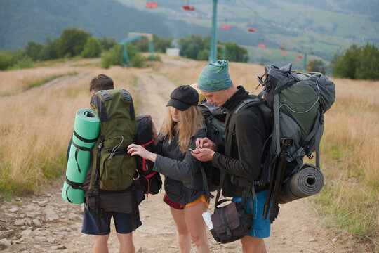 guys look at the route on the phone map and fasten their backpack