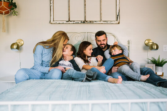 Family Cuddling on Bed