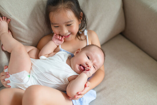 little asian girtl with her baby sister at home