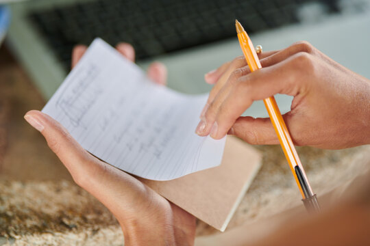 Sheet with notes in hands of woman with pencil