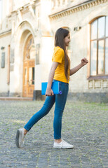 Little child girl back to school hold textbook, towards knowledge concept