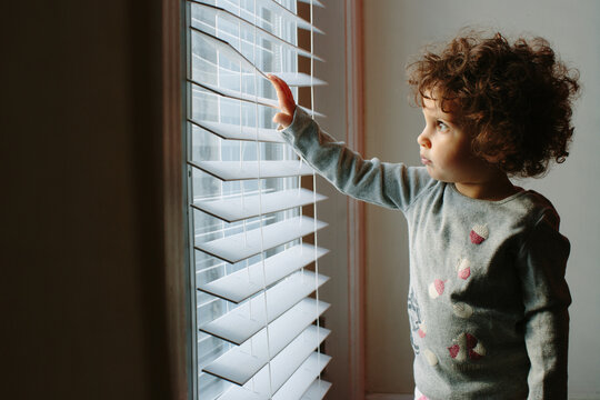 Kid touching window blinds