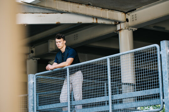 Pensive Young Man Alone in Parking Lot