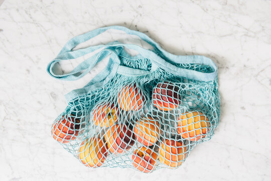 Peaches in a mesh shopping bag