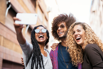 Multiethnic friends group taking selfie with mobile phone