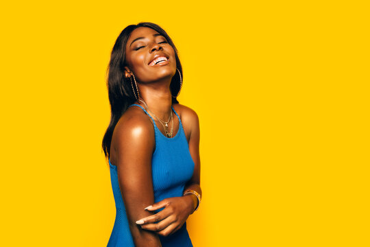 Happy Black Woman posing over yellow background