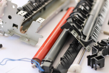 the fixing unit has been removed from the printer and is ready for repair, disassembled into parts