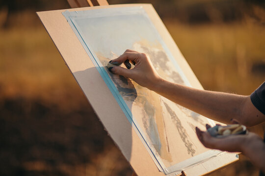 Crop artist drawing landscape with pastel