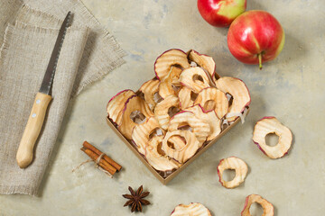 Apple organic chips in a cardboard box. Cinnamon and anise on a light background. Healthy vegan vegetarian fruit snack. Natural food product.