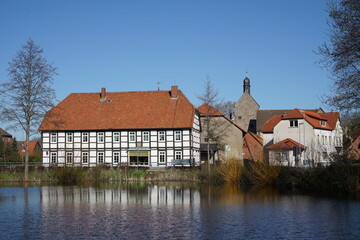Naklejka premium Spiegelung von Häusern im Wasser an einem Teich in einem Ort