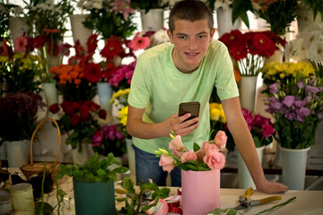 young boy florist works in a flower shop