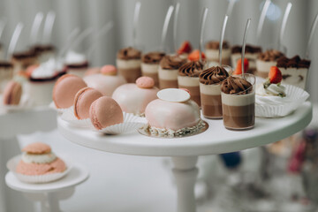 Candy bar. Dessert table with delicious cupcakes, pink macaroons, cakes, marshmallows. Strawberry on the top of marshmallow
