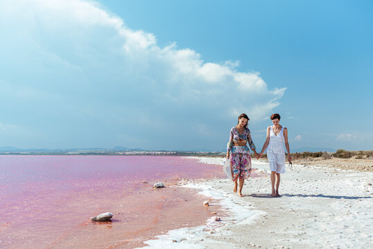 cute Women walking on a amazing pink lake holding hands