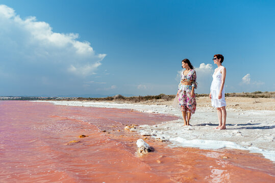 cute Women walking on a amazing pink lake