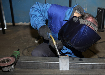 Electric arc welding. The worker welding two iron corners.