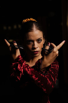 Young woman dancing flamenco on black
