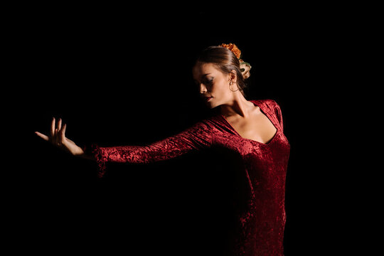 Young woman dancing flamenco on black
