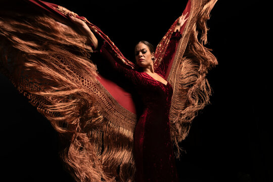 Young woman dancing flamenco on black