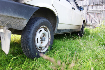 an old Soviet car stands in the grass