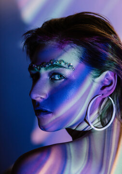 Young lady with jewels on face looking at camera