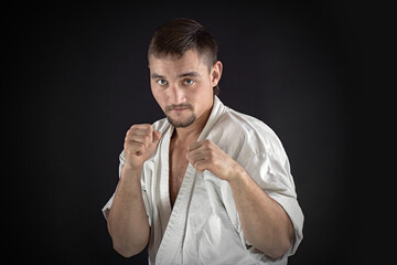 karate man training and posing on black background