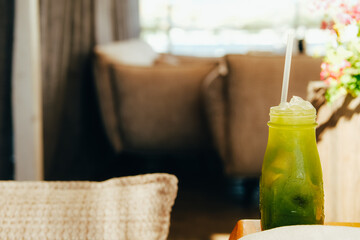 Matcha cocktail in tall glass on beige background.