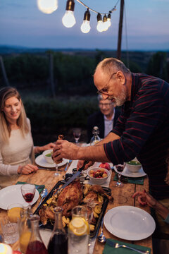 Middle-Aged Man Carves Up Roasted Turkey