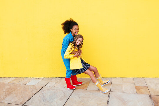 Black girl carrying cheerful friend