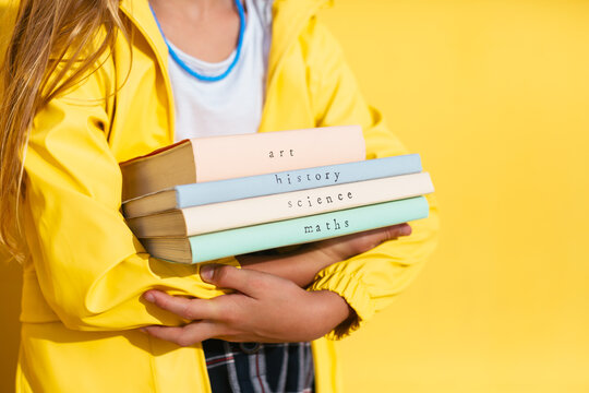 Crop girl with stack of textbooks