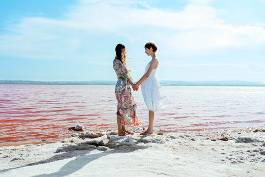 cute Women wearing summer dress standing on a amazing pink lake