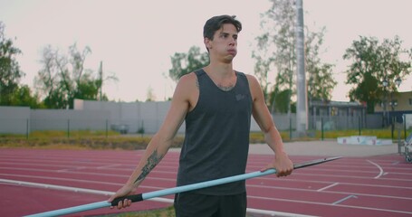 Sportsman doing javelin throw on athletic ground. Male athlete throwing the javelin in the olympic stadium. Athlete in sport clothes at athletic sport track in professional stadium