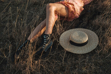 Close Up Of Woman Lying In The Grass Next To Straw Sun Hat