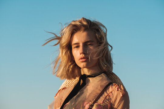 Portrait Of Fashionable Blond Woman Against The Blue Sky