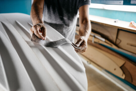 Anonymous shaper making a surfboard