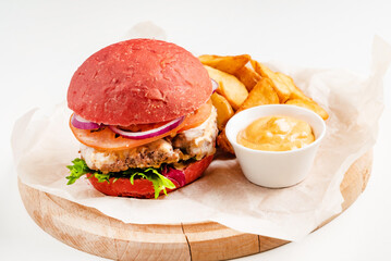 red burger with roasted potatoes and sauce