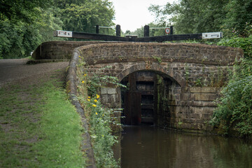 Fototapeta na wymiar Stone bridge in front of the canal lock, Peak Forest Canal near Manchester. 
