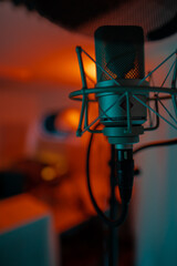 Mikrofon im Tonstudio mit oranger Hintergrundbeleuchtung