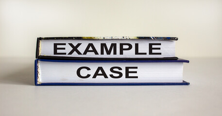 Books with text 'example case' on beautiful white table. White background. Business concept. Copy space.