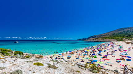 CALA MESQUIDA, MALLORCA, SPAIN - 19 July 2020: People enjoying beautiful sandy beach of on Mallorca, Mediterranean Sea, Spain.
