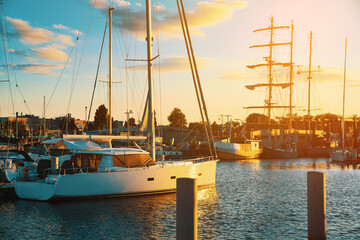 Boats in the port against the setting sun. Moored boats by the sea, sunset. The concept of sailing,...