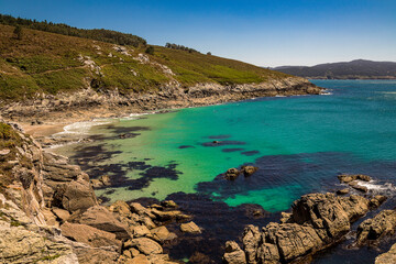Obraz premium Small Atlantic beach with turquoise blue, crystal clear water, fine sand and rocks. O Corvo beach. Lighthouse trail