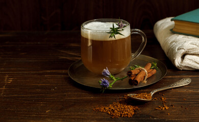 Coffee with milk foam from chicory root on a dark wooden background, horizontal orientation with space