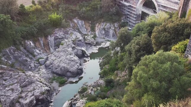 Small river and grea castle. Sunset at italian small town of Vulci. Great warm sunset with aerial view. Horses on background and gread landscape and view