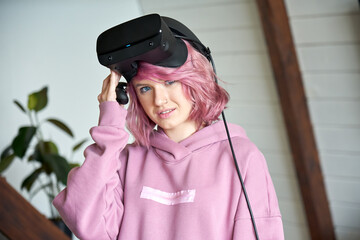 Hipster fashion teen girl with pink hair wear vr glasses headset hold controller look at camera. Digital innovation video gaming, virtual reality 3D 360 experience concept. Head shot face portrait.