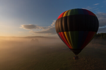 Hot air balloon lifting off on a foggy morning