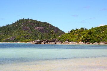 Fototapeta na wymiar Beautiful beach in Seychelles island, with turquoise blue water sea and white sand beach, granit rocks, mountain with green vegetation.