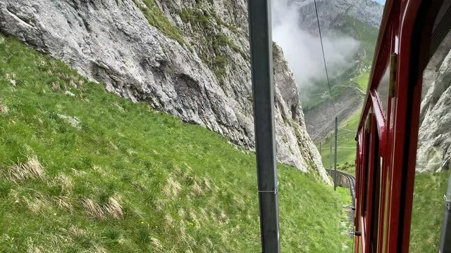 Red railcar on the way to the top of Mount Pilatus, Alpnachstad, Switzerland