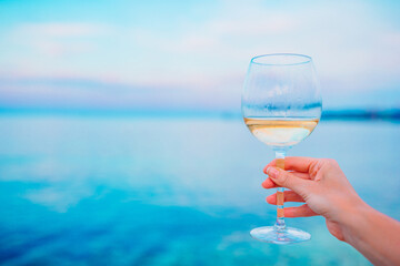 Glass of white wine on tropical beach