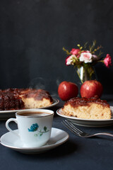apple pie with kitchen cutlery and coffee on a dark base with natural light